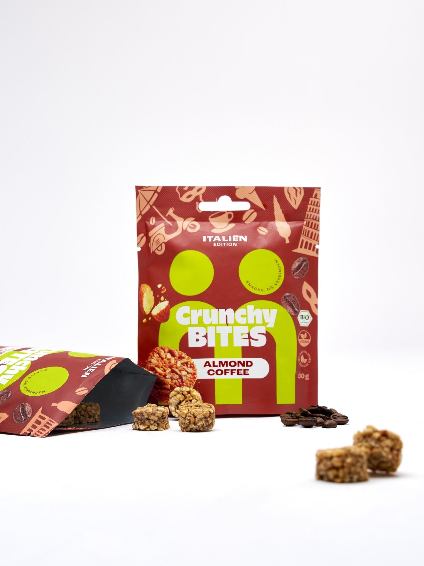 myBuddy Crunchy Nut Bites Almond Coffee aus dem 40er-Set, stehender 30-g-Beutel neben einem geöffneten Beutel mit ausgekippten Bites