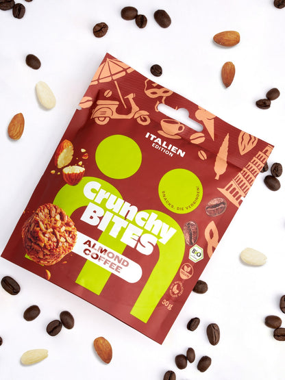 myBuddy Crunchy Nut Bites Almond Coffee aus dem 9er-Set, einzelner 30-g-Beutel im Flatlay mit Kaffeebohnen und Mandeln